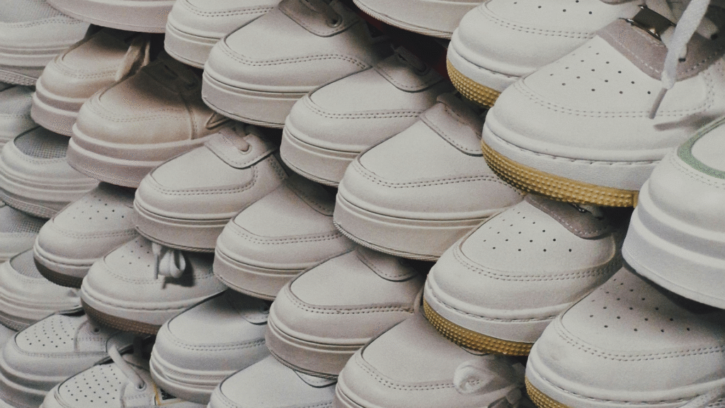 A dense, repetitive stack of numerous white platform sneakers arranged closely together.